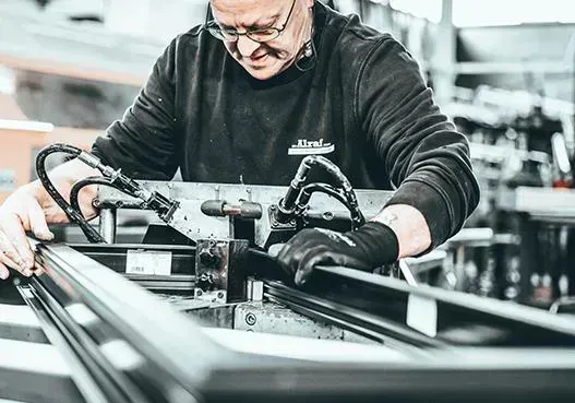 Een medewerker bewerkt een aluminium profiel