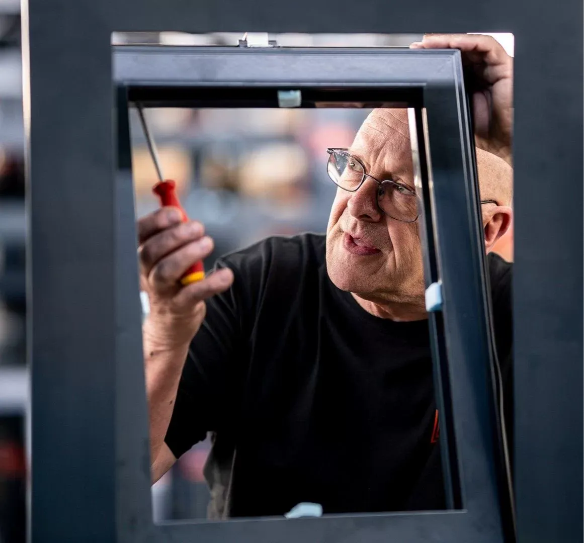 Een medewerker controleert een stalen kozijn