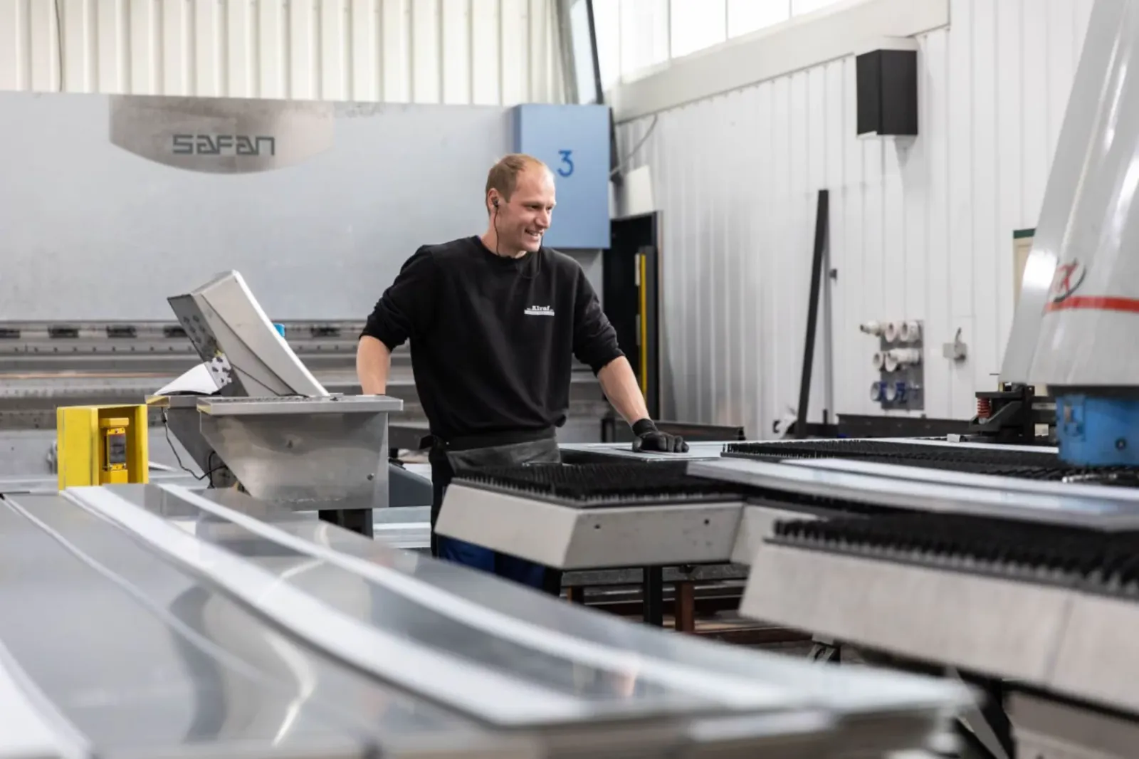 Een medewerker aan de CNC-gestuurde kantbank